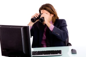 portrait of businessman looking monitor through binocular against white background